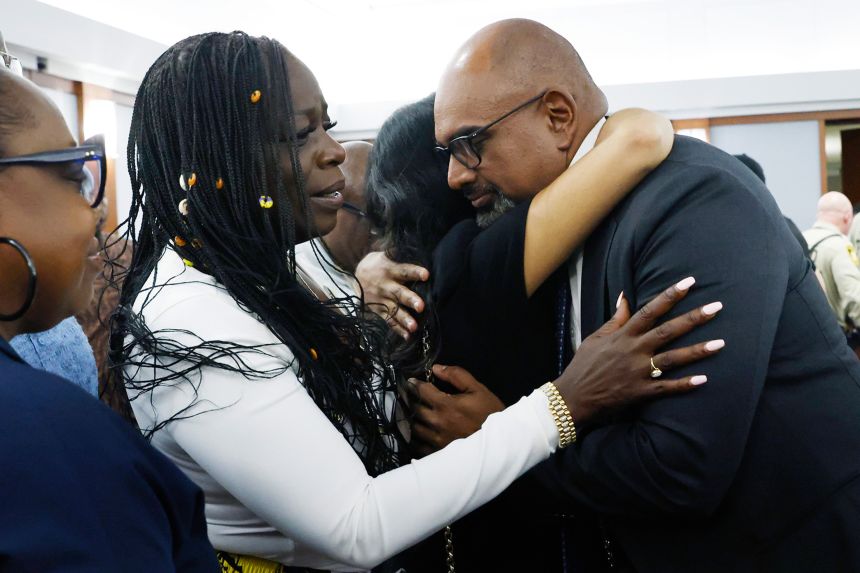 Friends and family members of rapper Tupac Shakur, including his sister Sekyiwa Shakur, second to left, line up to hug Chief Deputy District Attorney Binu Palal, right, after a jury found Duane Davis guilty of first-degree murder on August 31, 2026, in Las Vegas. Bizuayehu Tesfaye/Pool/Las Vegas Review-Journal/AP