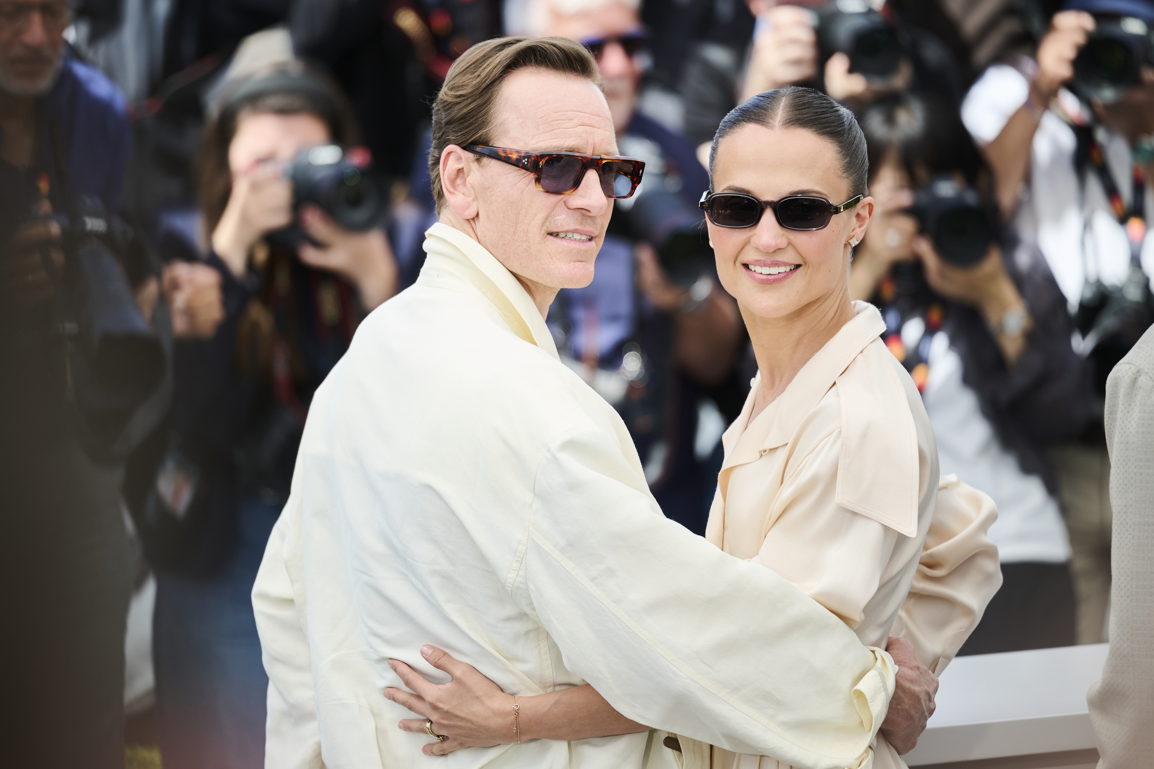 Michael Fassbender and Alicia Vikander embracing at the Hope photocall during the 2026 Cannes Film Festival