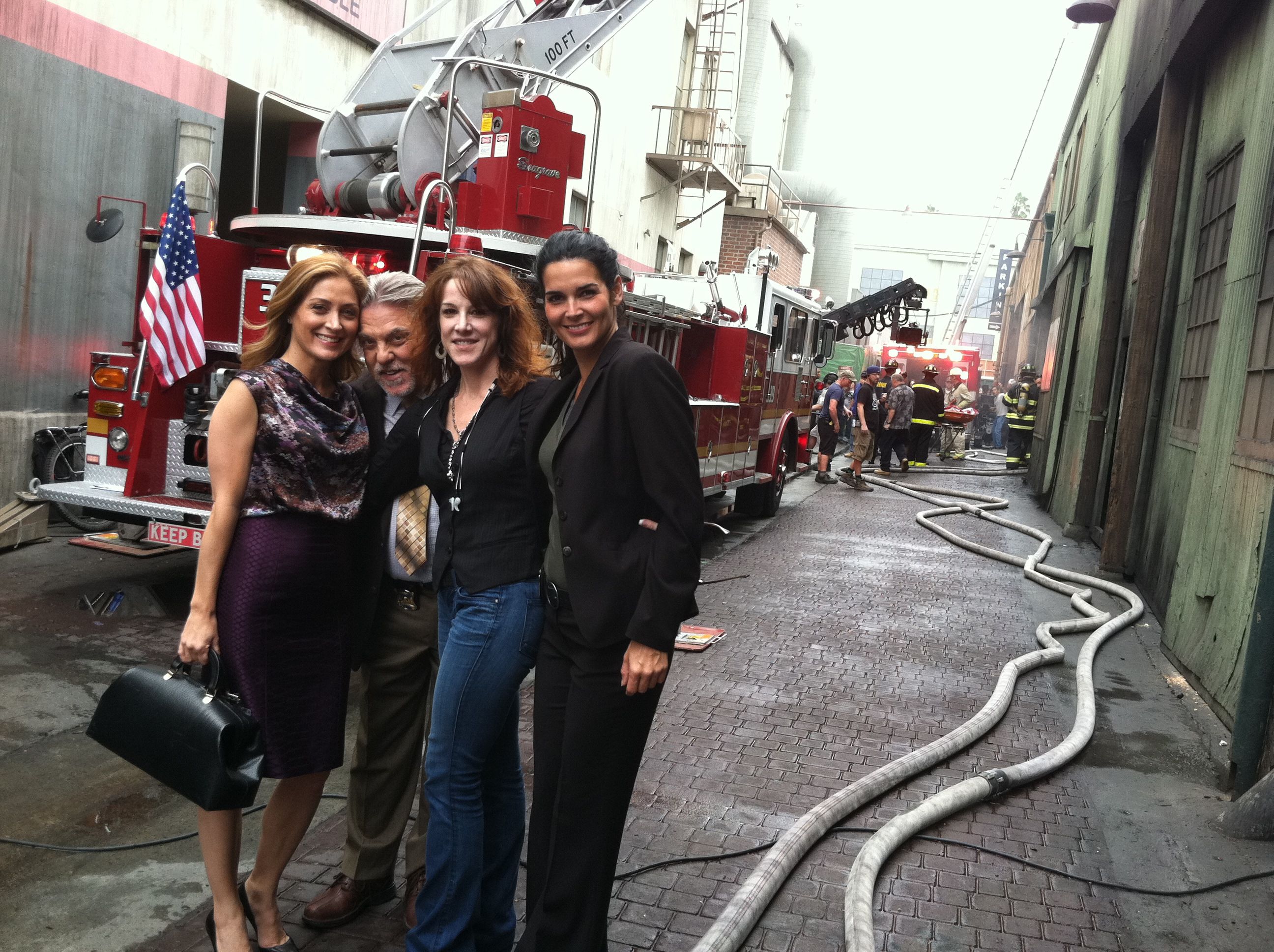 Sasha Alexander, Bruce McGill, Janet Tamaro and Angie Harmon beside a fire engine on the Rizzoli & Isles set in 2011.
