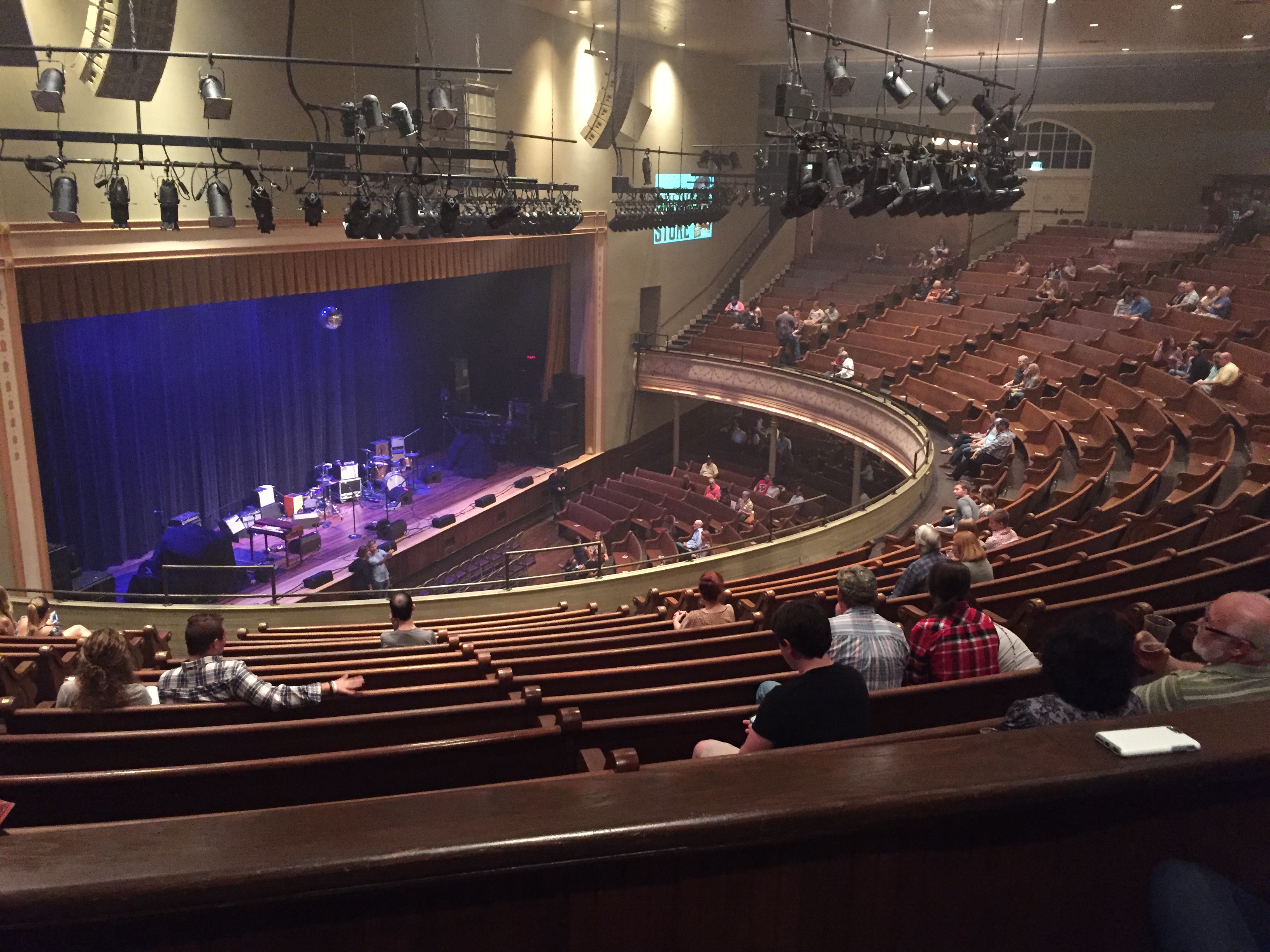 Interior of Ryman Auditorium viewed from the balcony with wooden pews facing the stage